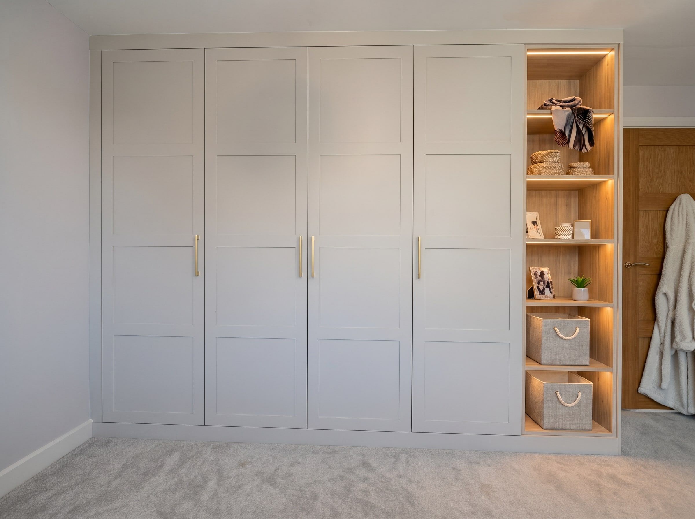 4-panel Contemporary Shaker fitted wardrobes in Cashmere with a natural oak-effect open bookcase lit by LED strips, Barrow upon Soar
