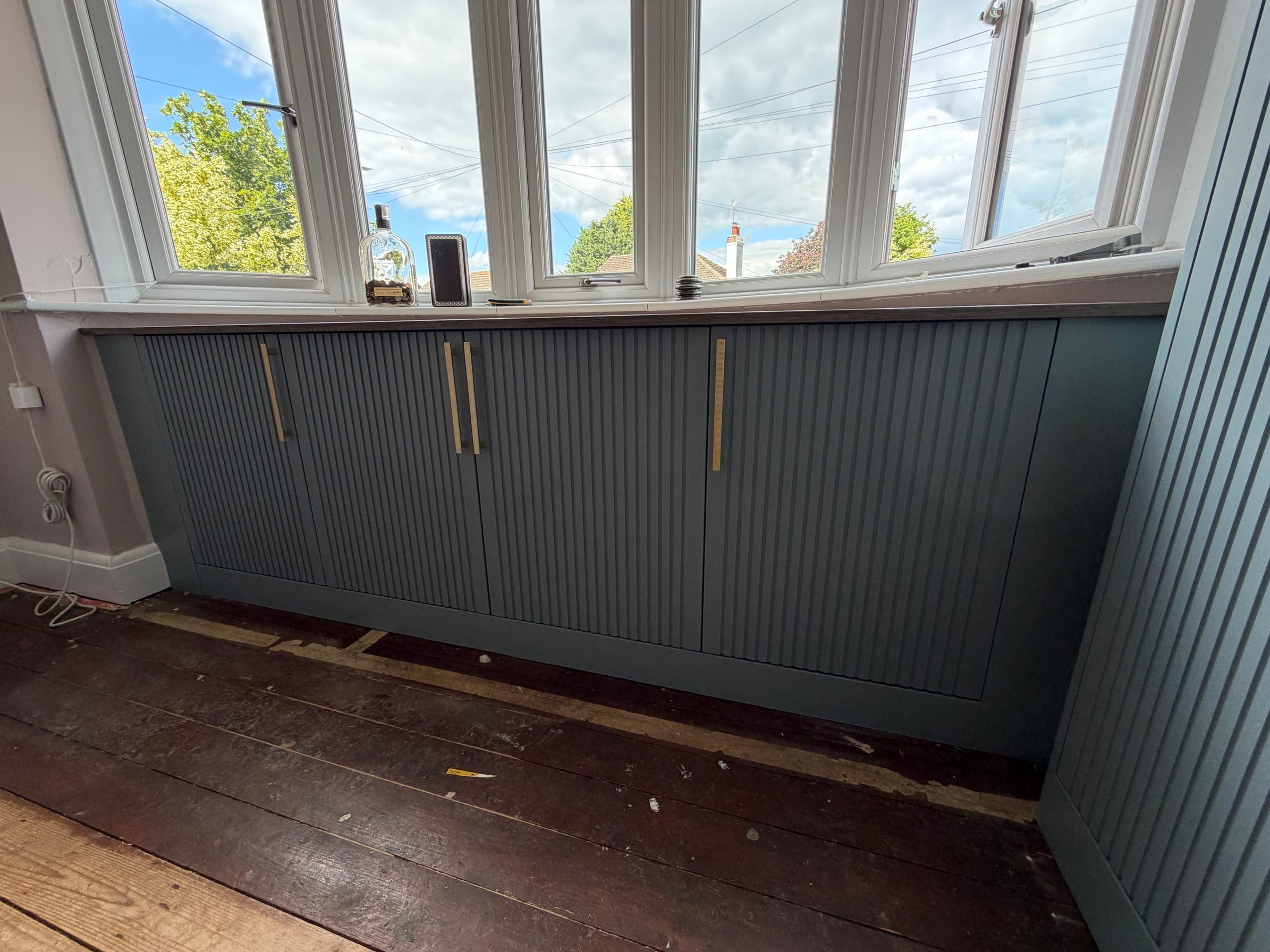 Low fluted Fjord matt units fitted under the bay window in the same Sileby bedroom