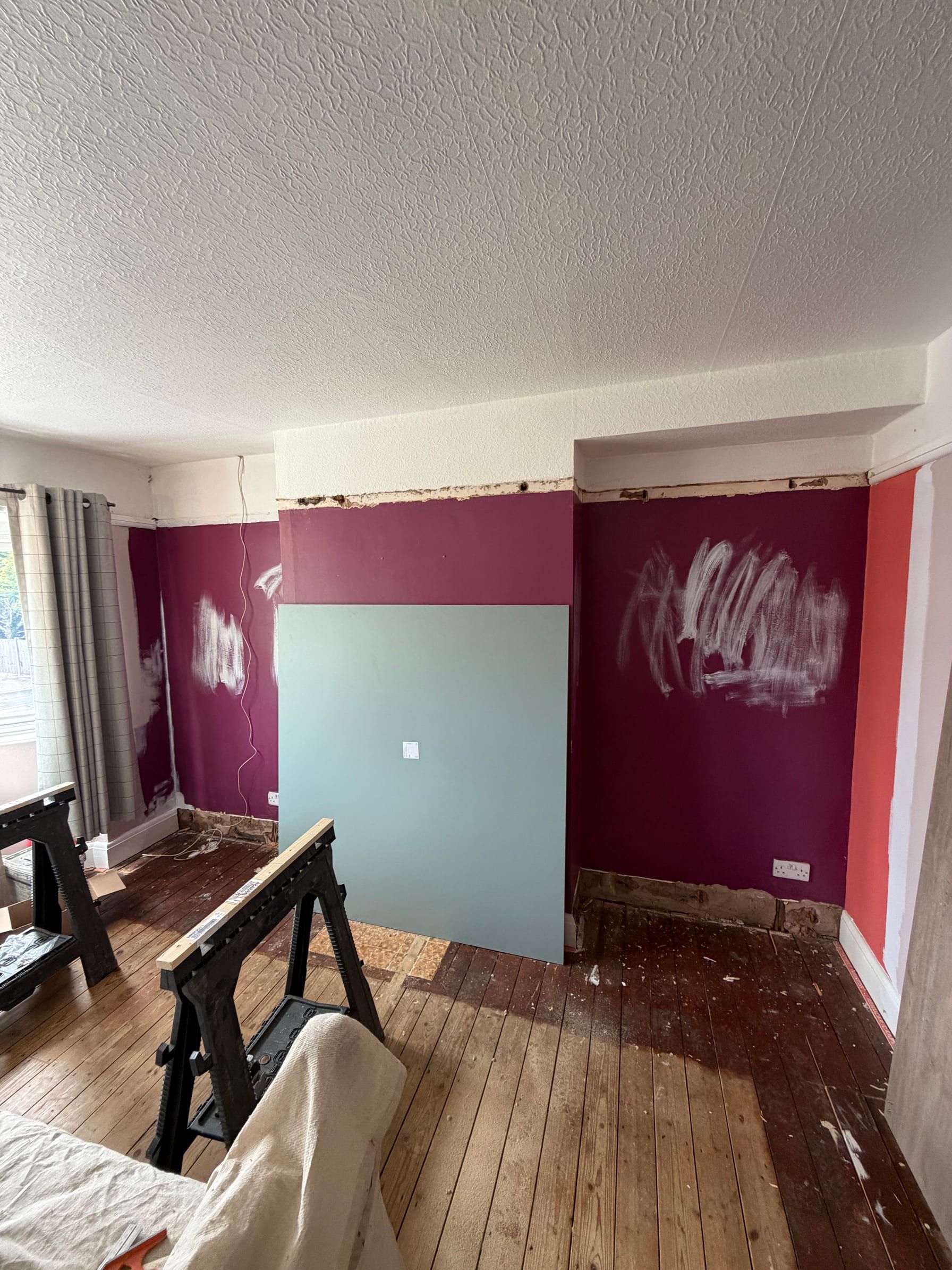 The Sileby bedroom before: stripped walls and floorboards, with the first panel against the wall