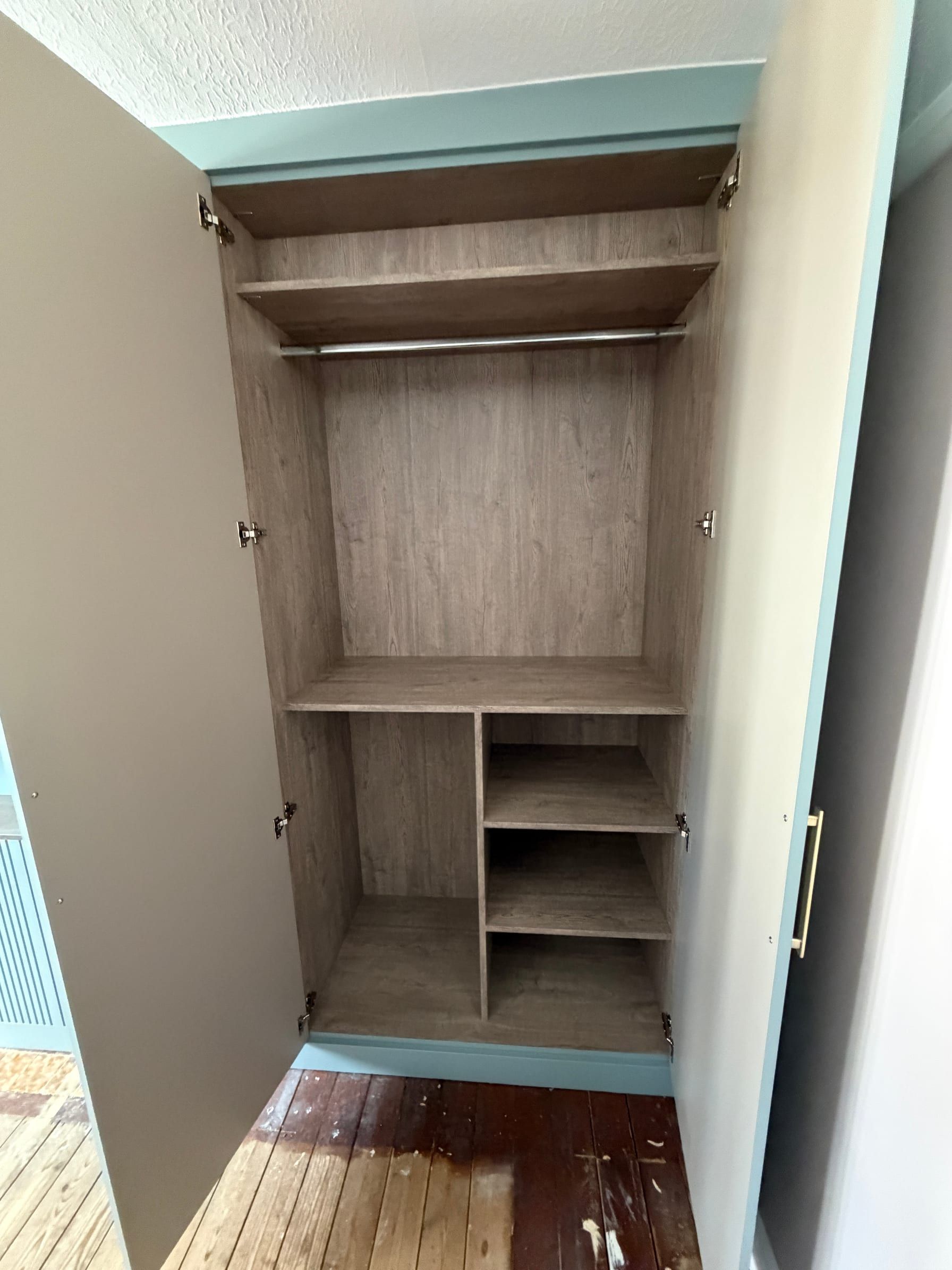 A Sileby wardrobe open to show wood-effect interiors with long and double hanging and shelves