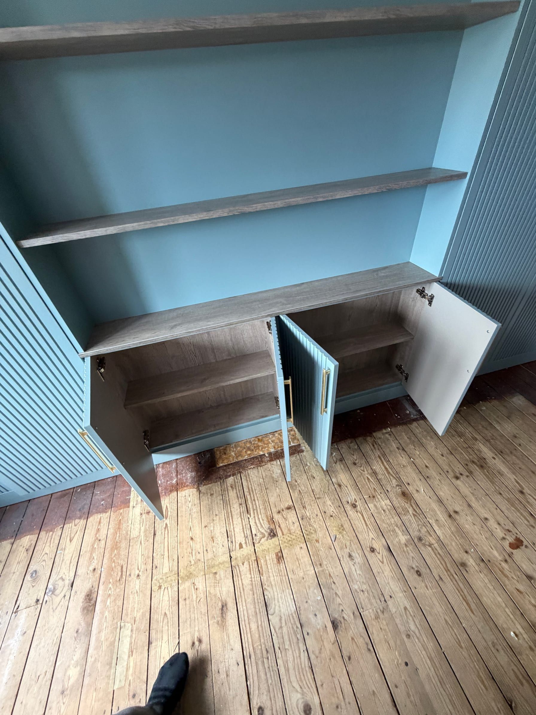 A Sileby wardrobe open to show hanging space above shelves and open cubbies